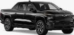 A black, four-door pickup truck is pictured in a studio setting, viewed from a front-side angle.